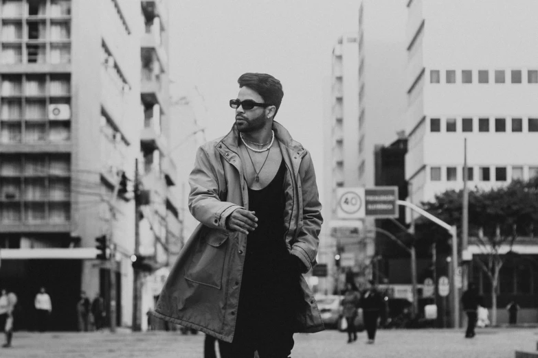 a man in sunglasses and jacket is standing on the street