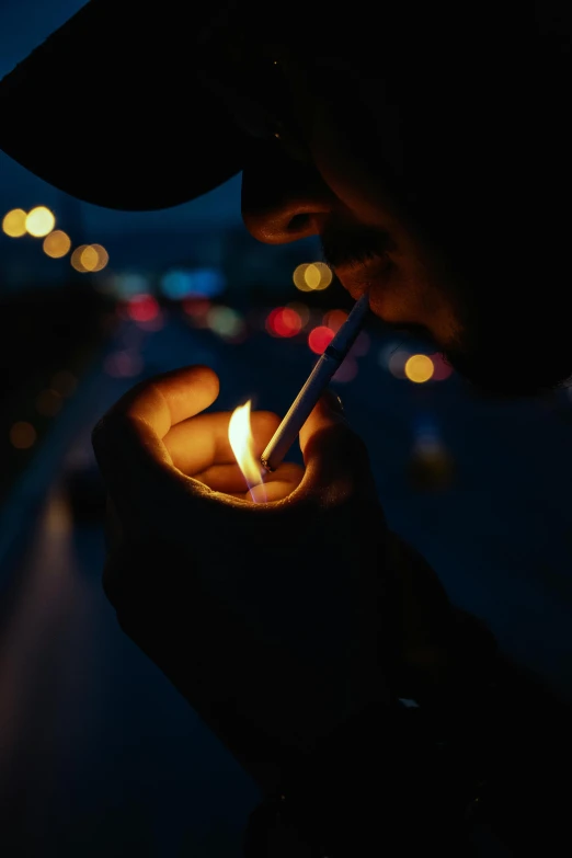 a person with dark hair holds a lit match in their hand