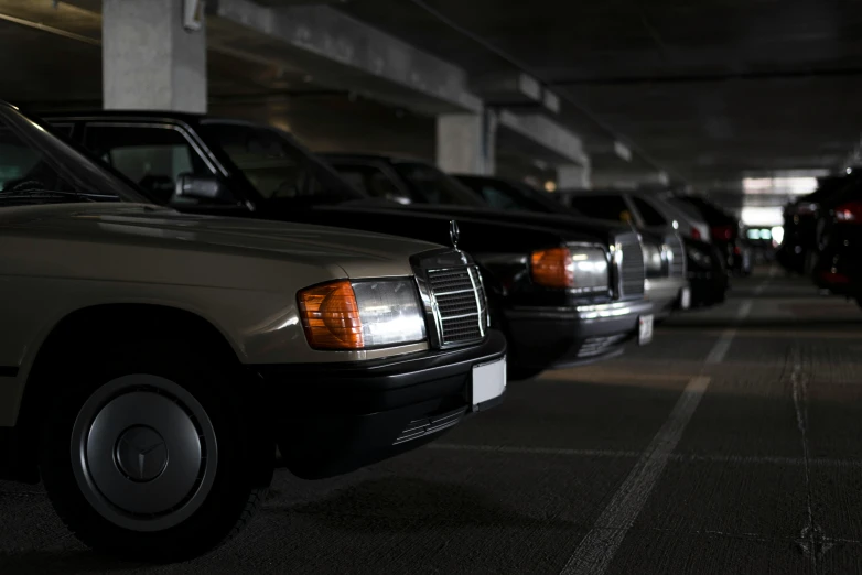 a row of cars parked under an overpass at night