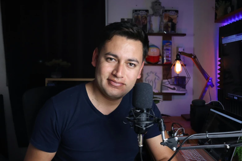 a man holding a microphone sits in front of a radio