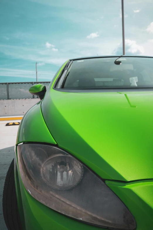 a bright green sports car sitting in a parking lot