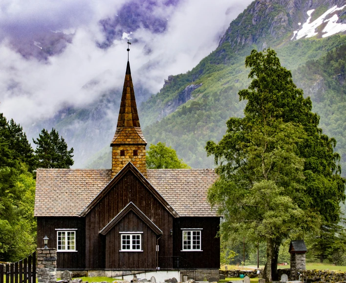 a small church sits in front of mountains