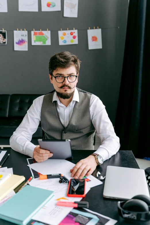 man in office looking at paperwork and binders