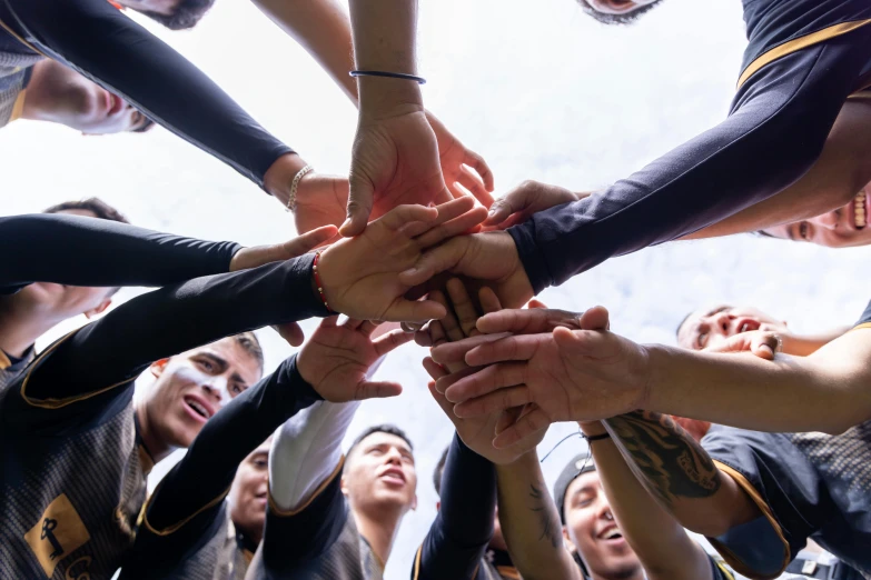 a team standing together with their hands in the middle