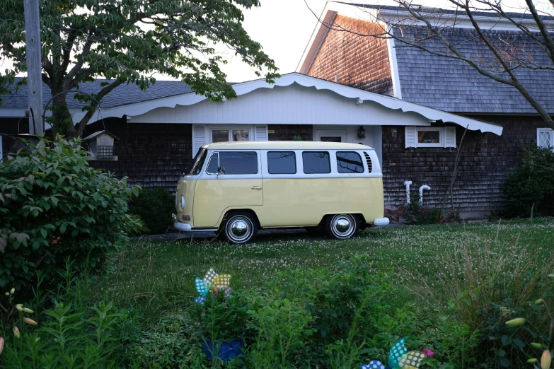 a yellow and white van parked in front of a house