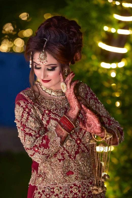 a woman in red indian dress with lights behind her