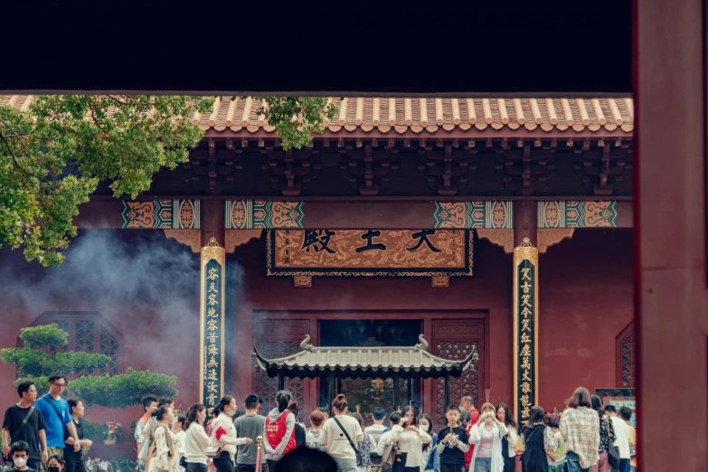 a crowd of people outside of a building next to a tree