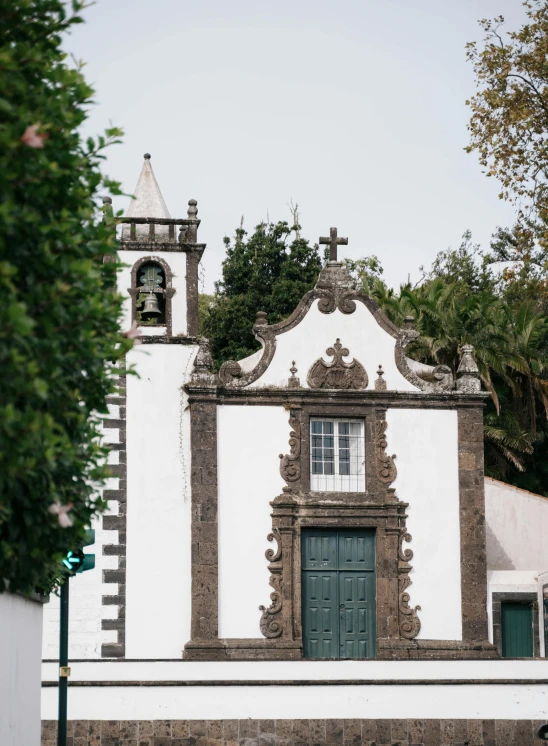 a white building with a green door and a tower