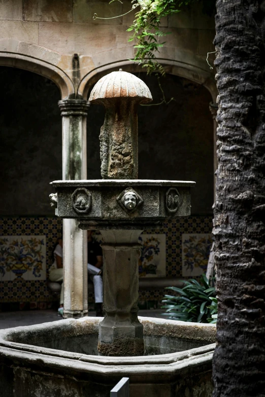 a fountain in a courtyard next to trees