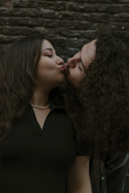 a woman and man kiss while one kisses the other