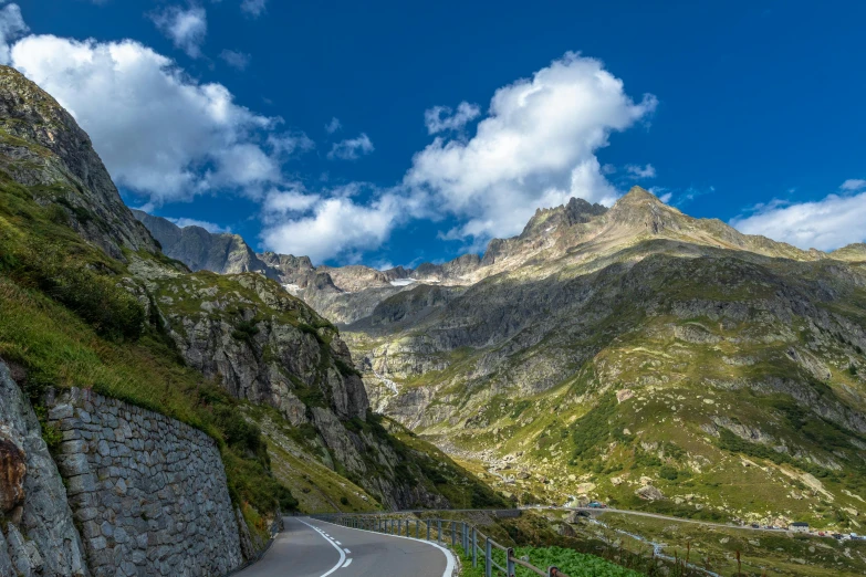 a mountain road winding into a valley near a river