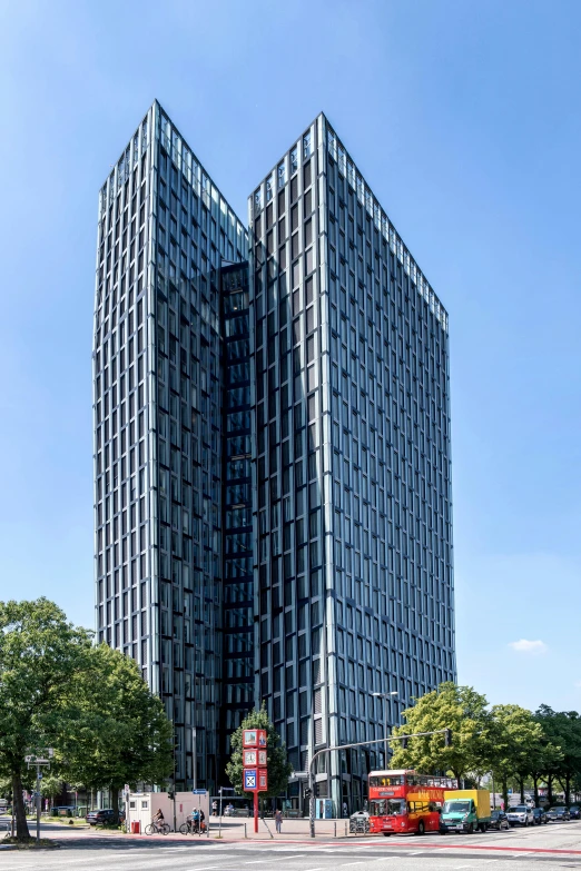 an unusual black building in the city with cars on it