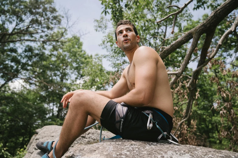 young man with his  sitting on top of rock