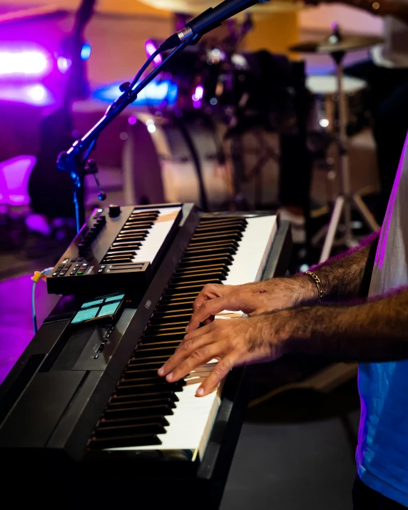 a man standing in front of a keyboard with a microphone