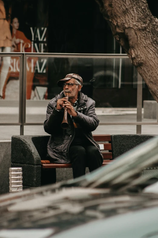 a man sitting on a bench smoking a cigarette