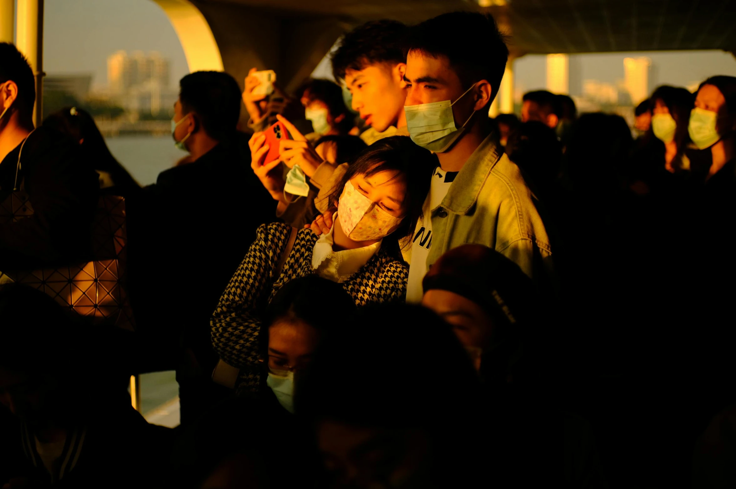 people wearing face masks looking at their phones