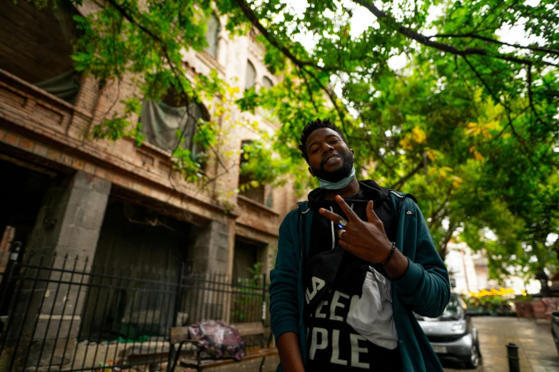 a man standing on a street corner holding up a smart phone