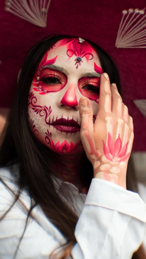 woman with face painted holding an umbrella with her hands