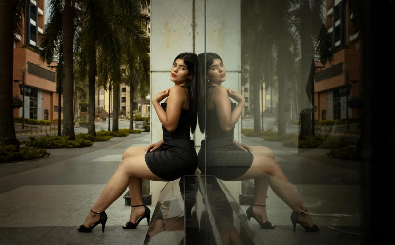 two women are posing with their backs to one another