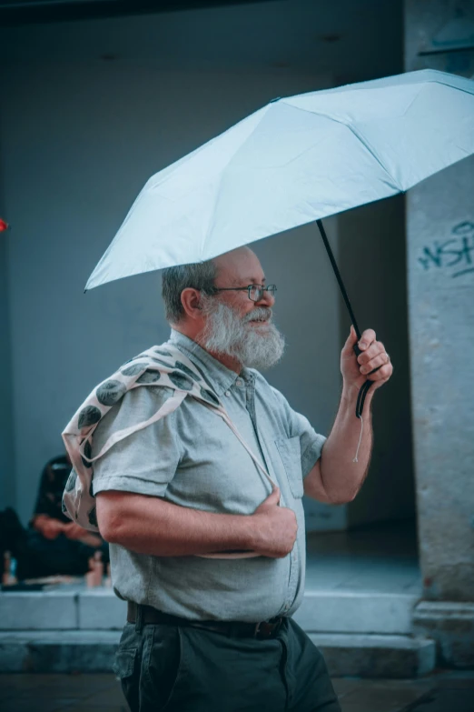 a man standing with an umbrella in the rain