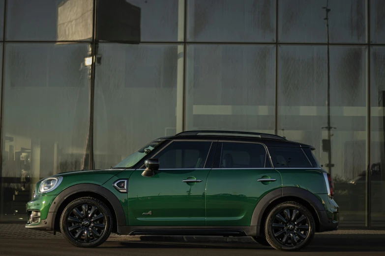 a green minivan is parked in front of an industrial building