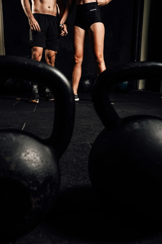 a man and woman looking at each other while standing in front of large exercise balls