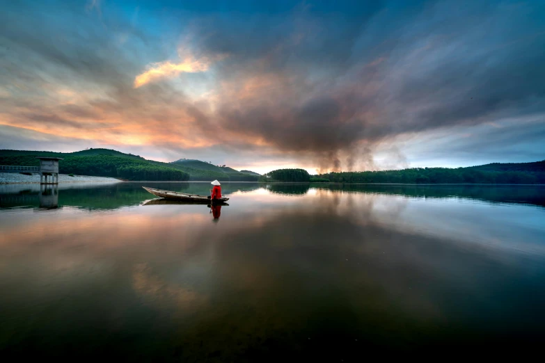 a man in a red shirt rowing a canoe through the water