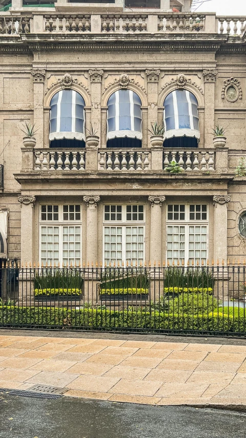 a large tan building with windows and a clock