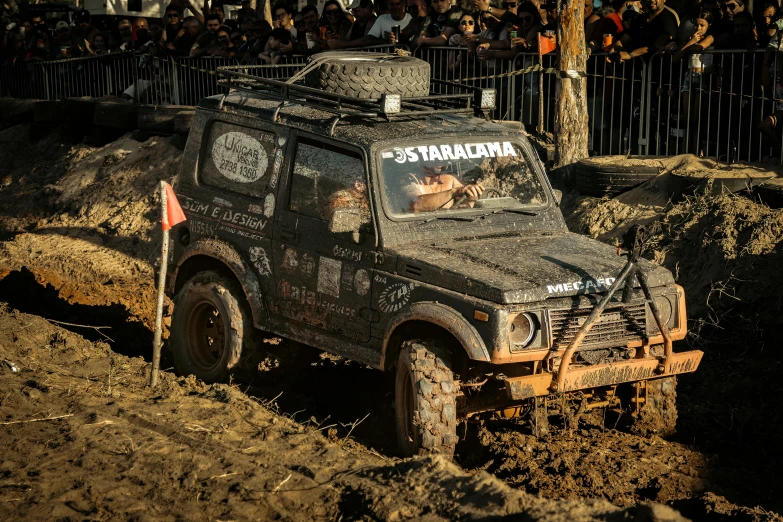 a black jeep is driving down a muddy road