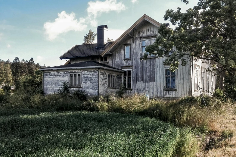 an old, rundown house sits on the corner of a grassy yard