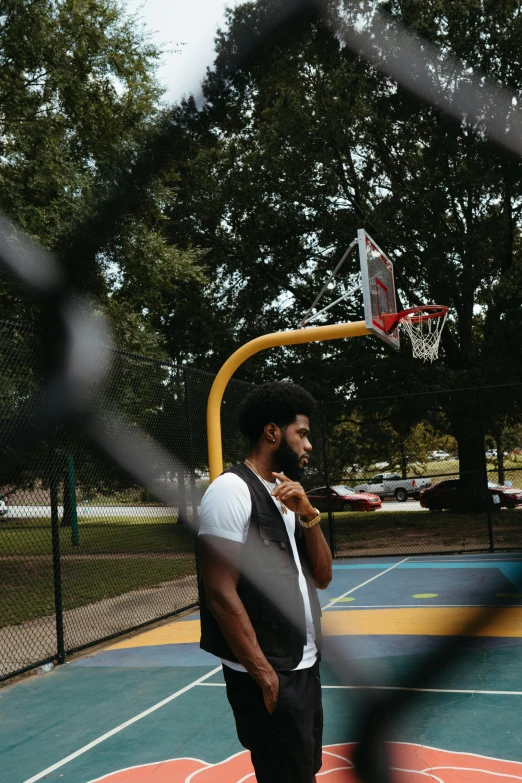 a man on a basketball court talking on a phone