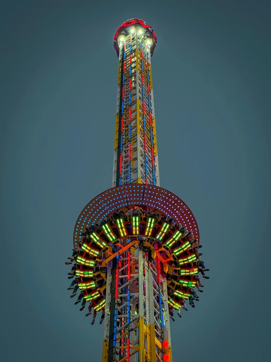a carnival rides on a very tall pole