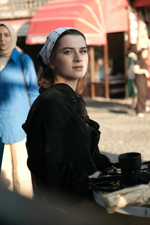 woman in black shirt standing near a table outside