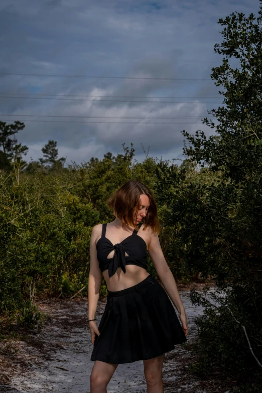 a girl wearing a black outfit is walking in the rain