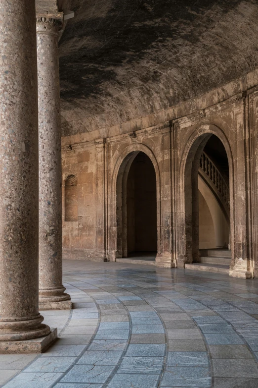 a stone courtyard with multiple arches and pillars