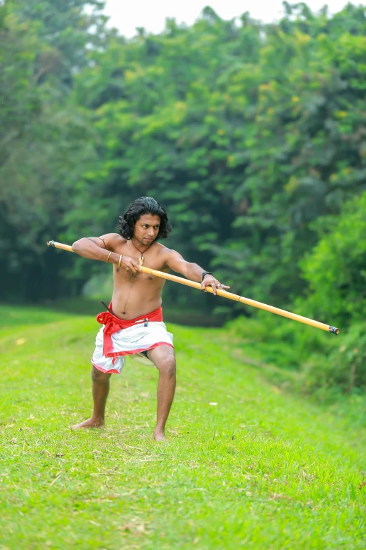 a man in the grass playing with a stick