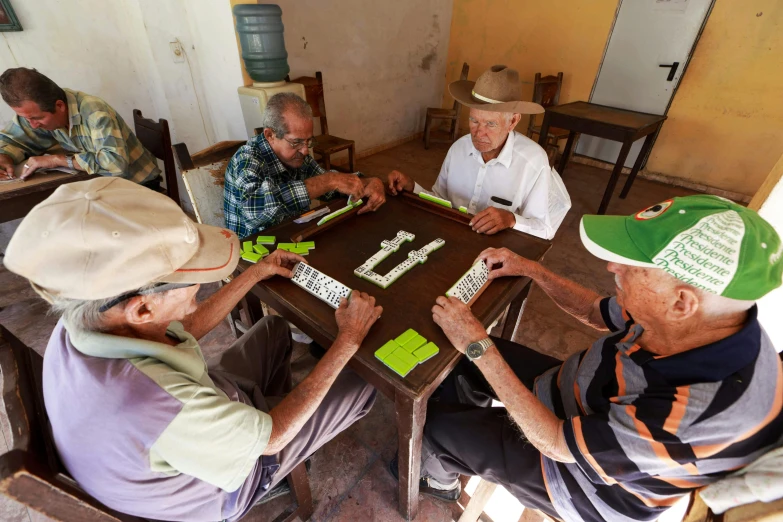 group of men sitting at a table playing a game