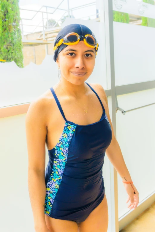 young woman posing in swimsuit with goggles on