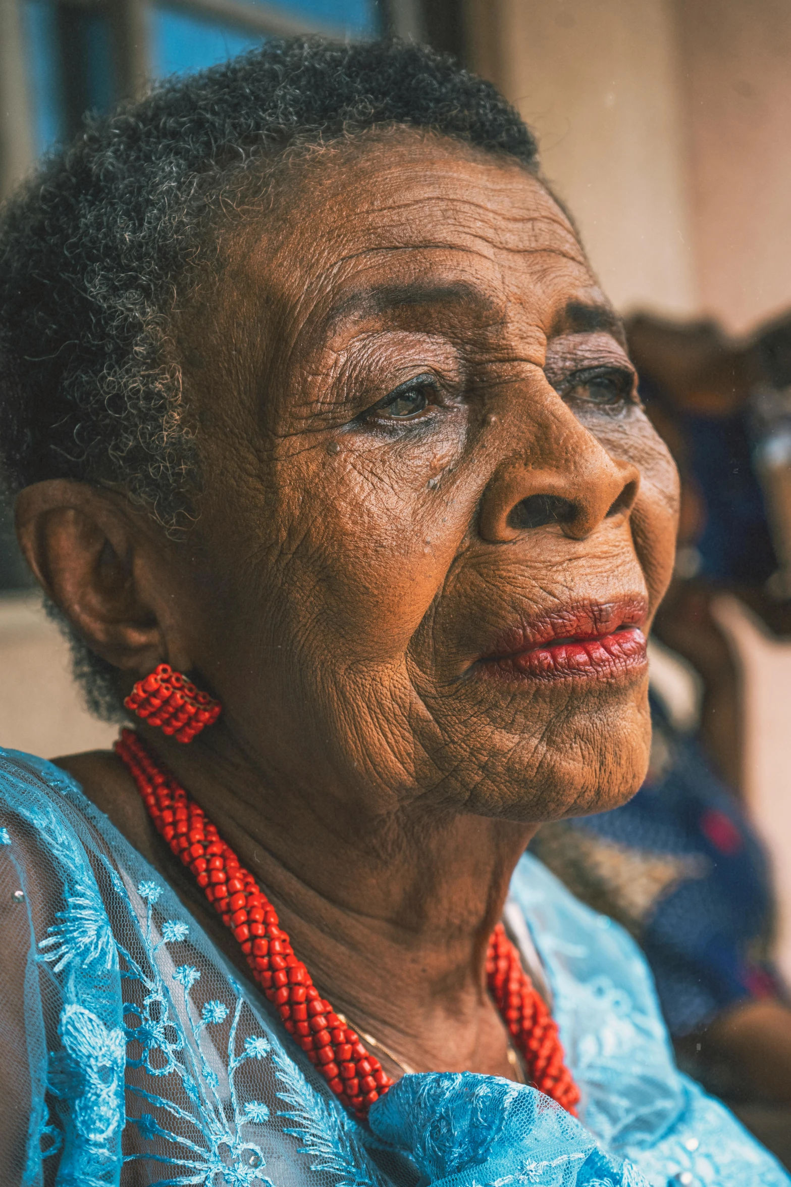 a woman with a red necklace on her neck