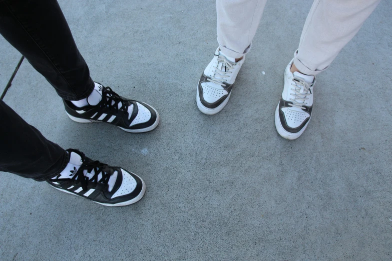 three people are standing on the concrete looking down