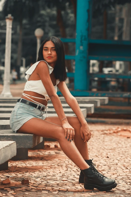 a beautiful young woman wearing a white top and denim skirt