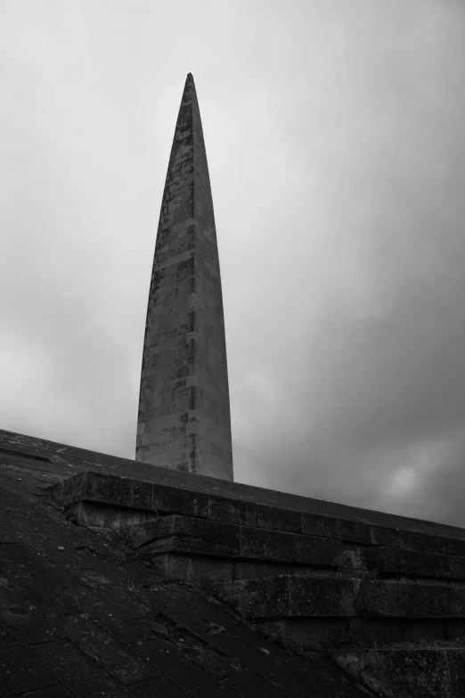 an obelisk standing in front of a stormy sky