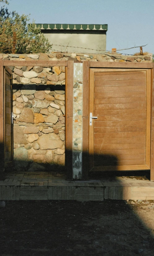 two wooden doors are open near a rock building