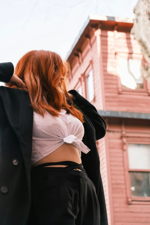 a woman standing on the street next to a building