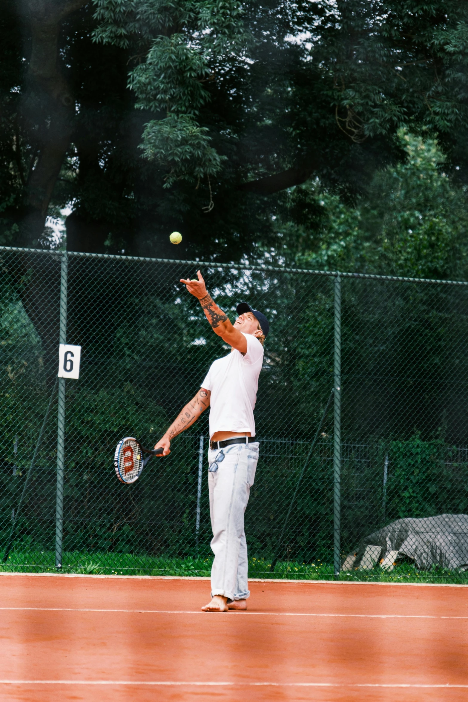 a man in white is hitting a tennis ball