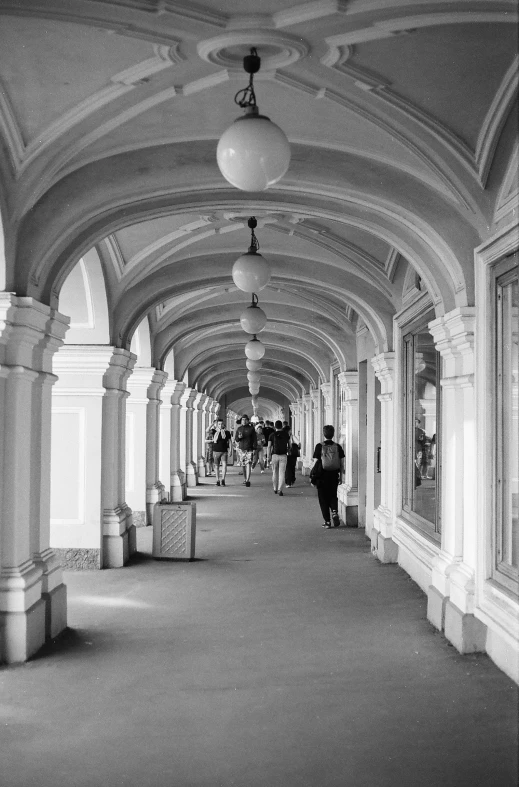 black and white po of people walking down an open hallway