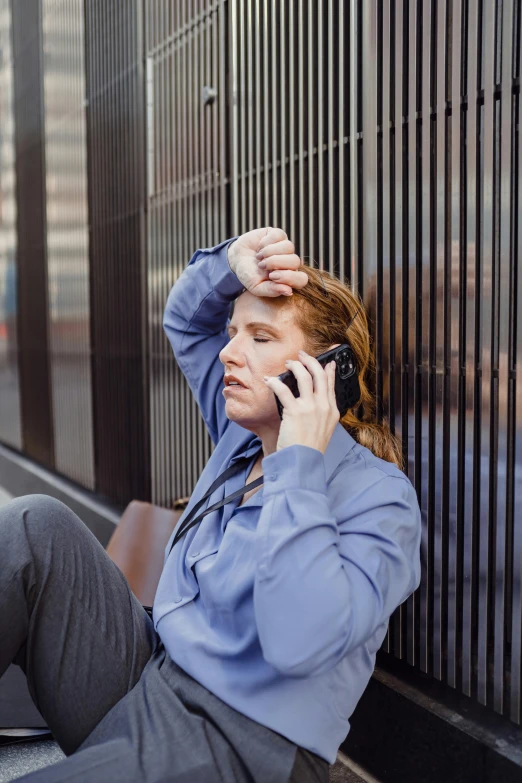 a woman in business attire on the phone outside