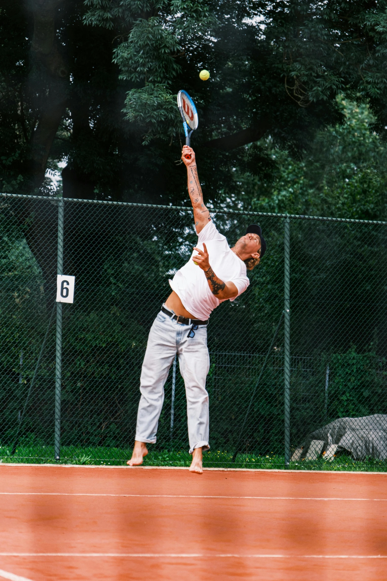 a man is holding a tennis racket preparing to swing it