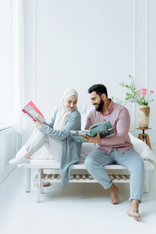 two people are sitting on a bench reading books