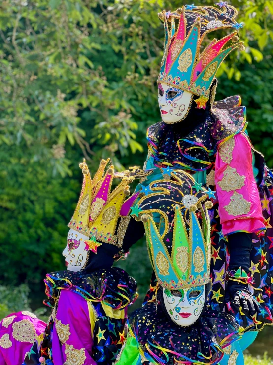 three people in colorful costumes with their faces painted